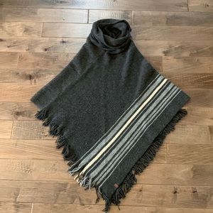 Women’s grey Roots poncho with cowl neck and fringe.